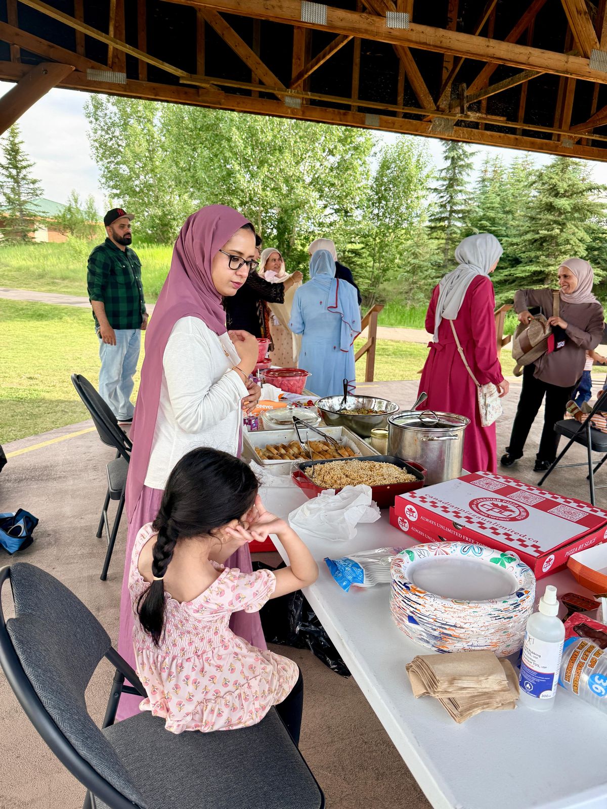 Families sharing food at an outdoor Muslims of Cochrane gathering